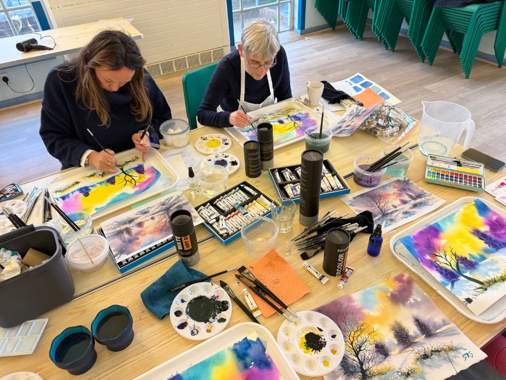 Close up of student learning watercolour techniques with artist guidance
